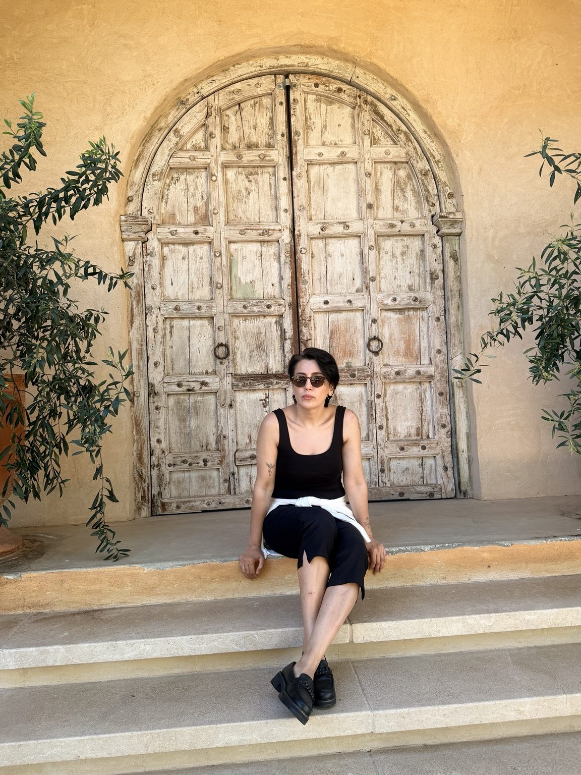Vera seated in front of a beautiful rustic doorway